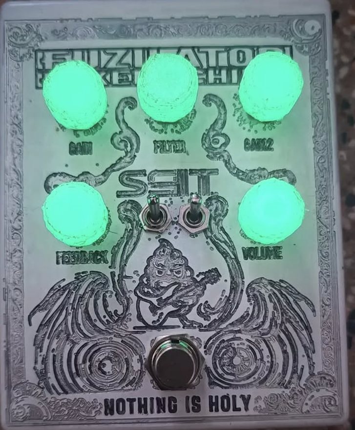 A Fuzilator with glowing green knobs and an engraved silver panel